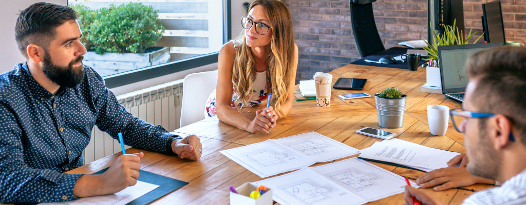 Empresarios en una reunión de trabajo mirando un dibujo de construcción